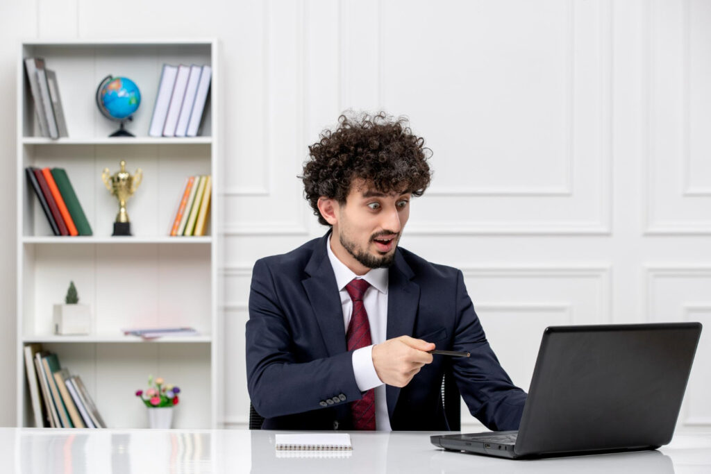 men working on laptop and hold a pen in his hand