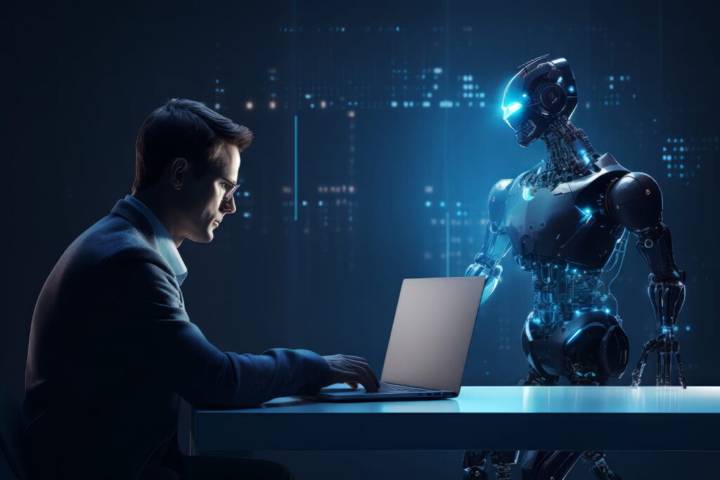 man working on laptop and there is a robot in front of him