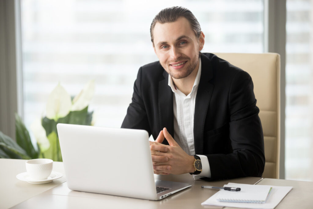 men give a pose in office while working on laptop