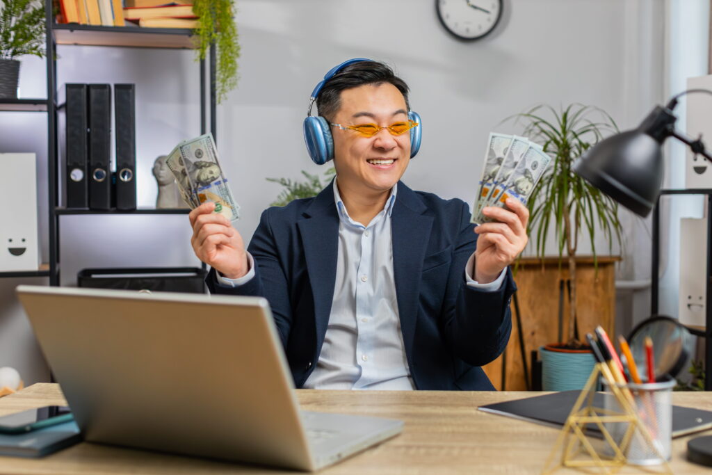 a asian man holding man he earn from freelanccing