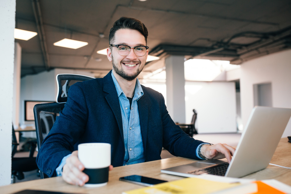men working on laptop and hold a cup of tea